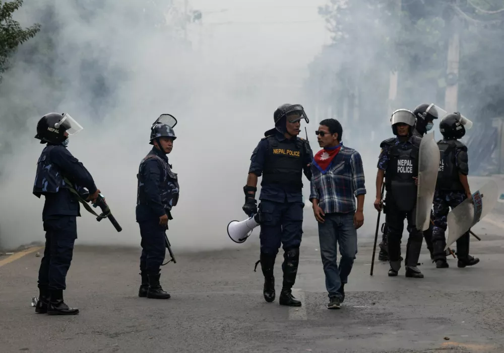 A riot police officer interrogates a demonstrator during a protest against corruption and the government's decision to block several social media platforms, in Kathmandu, Nepal, September 8, 2025. REUTERS/Navesh Chitrakar