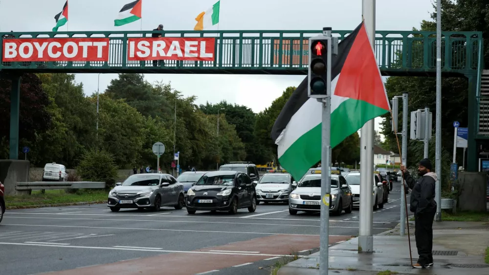 Pro-Palestinian protestors hold flags and a sign on a motorway overpass outside the RTE (Radio Telefis Eireann) Irish public service broadcaster television studios, in Dublin, Ireland, September 11, 2025. REUTERS/Clodagh Kilcoyne