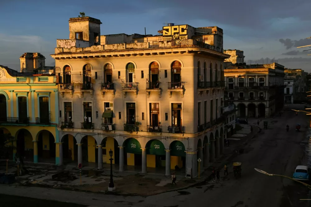 People walk along the street at sunset during a national power grid collapse, the fourth in less than a year, which caused a nationwide blackout, in Havana, Cuba September 10, 2025. REUTERS/Norlys Perez