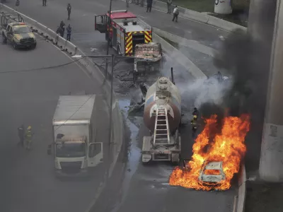 A vehicle burns near the site of a gas tanker explosion under a highway overpass in Mexico City, Wednesday, Sept. 10, 2025. (AP Photo/Tristan Velazquez)