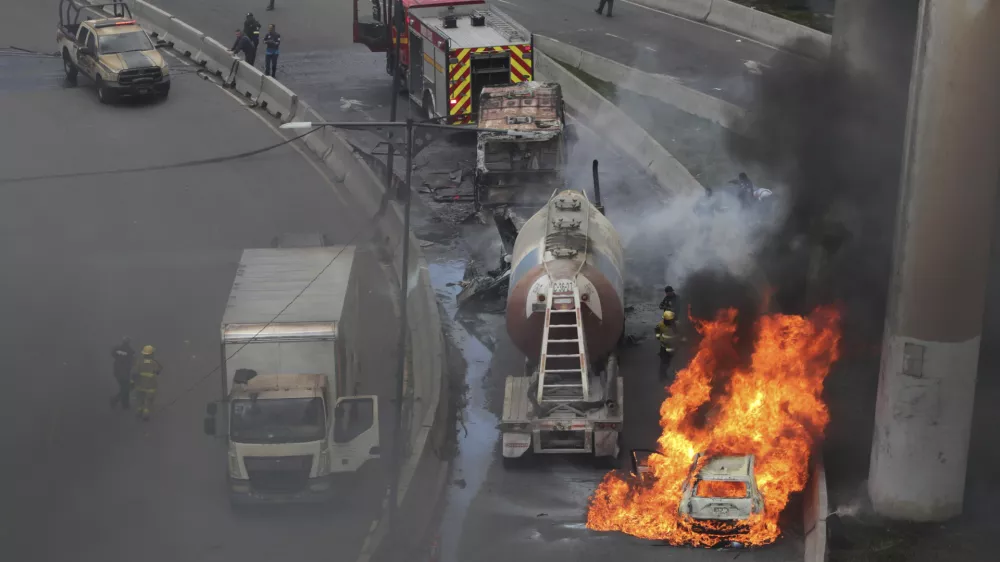 A vehicle burns near the site of a gas tanker explosion under a highway overpass in Mexico City, Wednesday, Sept. 10, 2025. (AP Photo/Tristan Velazquez)