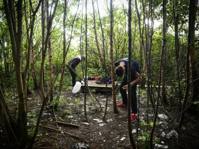 Drug addict Michael (R) is seen preparing to inject cocaine in a small wooded area used by addicts to take drugs near Glasgow city centre, Scotland, on August 15 2019. Drug addict Michael arrives at a derelict scrap of land near Glasgow city centre littered with used syringes and other drug detritus to inject cocaine. He is helped by a fellow user who quickly mixes the white powder with distilled water in a small spoon and draws the liquid up into two needles. Moments later, the pair, barely hidden in the wasteland site, drop their trousers and shoot the narcotic-laced fluid into their leg veins. The pair are examples of worsening drug misuse across Scotland, where drug-related death rates are now among the worst in the developed world.,Image: 468832569, License: Rights-managed, Restrictions: TO GO WITH AFP STORY BY JOE JACKSON, Model Release: no