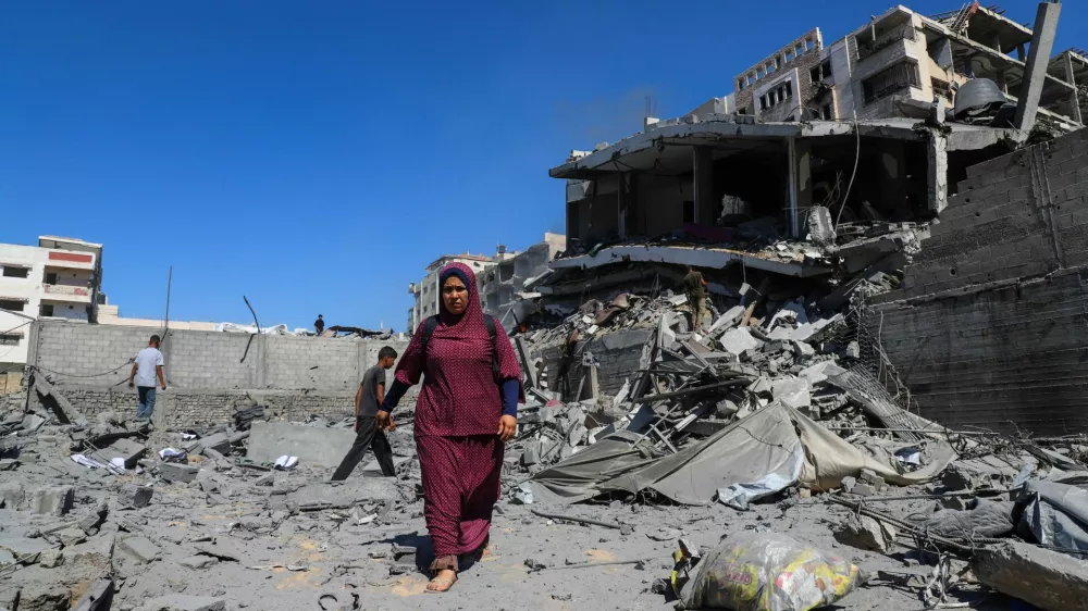 Palestinians inspect the site of an evacuated residential building, which was housing displaced Palestinians, after it was hit by an Israeli air strike, in Gaza City, September 12, 2025. REUTERS/Ebrahim Hajjaj