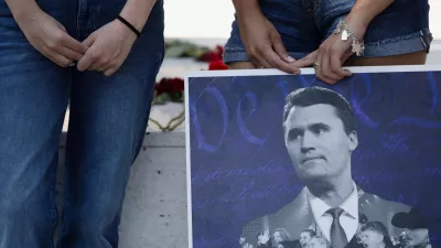 Jordyn Hackner, president of Turning Point USA's University of Houston chapter,and Lizbeth Aguilar stand behind a poster of conservative activist Charlie Kirk as people mourn following his fatal shooting, at the University of Houston in Houston, Texas, U.S., September 11, 2025. REUTERS/Antranik Tavitian   TPX IMAGES OF THE DAY