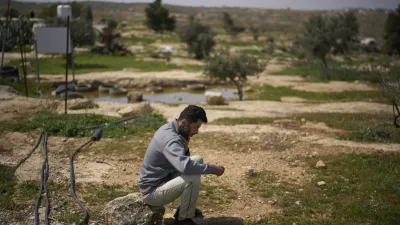 FILE - Basel Adra, one of the directors of the Oscar winner documentary "No Other Land", speaks on the phone as he sits in an area near the house of Palestinian co-director Hamdan Ballal, in Susiya in Masafer Yatta, south Hebron hills, March 25, 2025. (AP Photo/Leo Correa, File)