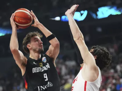 Germany's Franz Wagner, left,&nbsp;tries to score as&nbsp;Turkey's Cedi Osman blocks him during the Eurobasket, European Basketball Championship final match between Turkey and Germany at the Riga Arena in Riga, Latvia, Sunday, Sept. 14, 2025. (AP Photo/Sergei Grits)