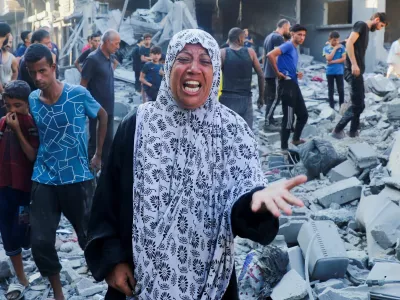 A woman reacts as palestinians inspect the site of an overnight Israeli strike on a house in Gaza City, September 16, 2025. REUTERS/Ebrahim Hajjaj