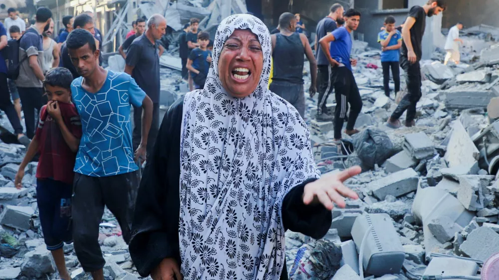 A woman reacts as palestinians inspect the site of an overnight Israeli strike on a house in Gaza City, September 16, 2025. REUTERS/Ebrahim Hajjaj