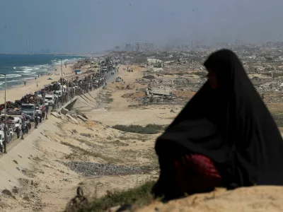 A woman observes, as displaced Palestinians, fleeing northern Gaza due to an Israeli military operation, move southward after Israeli forces ordered residents of Gaza City to evacuate to the south, in the central Gaza Strip, September 17, 2025. REUTERS/Mahmoud Issa   TPX IMAGES OF THE DAY