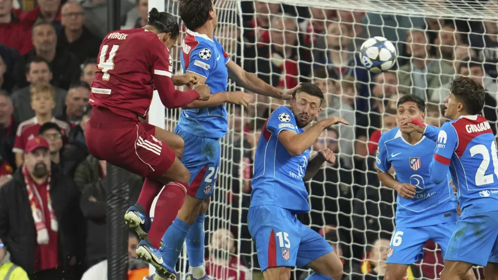 Liverpool's Virgil van Dijk, left, scores his side's third goal during the Champions League opening phase soccer match between Liverpool and Atletico Madrid at Anfield stadium in Liverpool, England, Wednesday, Sept. 17, 2025. (AP Photo/Jon Super)