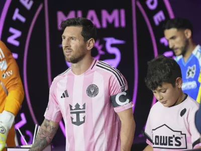 Inter Miami forward Lionel Messi, left, walks onto the field before an MLS soccer match against the Seattle Sounders, Tuesday, Sept. 16, 2025, in Fort Lauderdale, Fla. (AP Photo/Lynne Sladky)