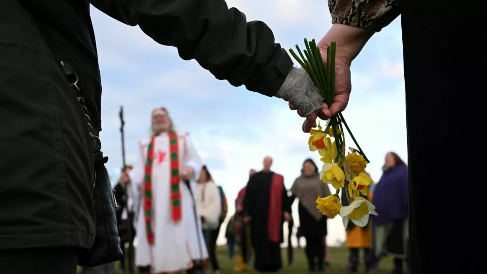 A reveller holds flowers as they attend spring equinox celebrations at Stonehenge stone circle, near Amesbury, Britain, March 20, 2025. REUTERS/Jaimi Joy