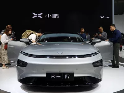 FILE PHOTO: People look at XPeng's P7 sedan model displayed at the Guangzhou auto show in Guangzhou, Guangdong province, China November 22, 2019. Picture taken November 22, 2019. REUTERS/Yilei Sun/File Photo