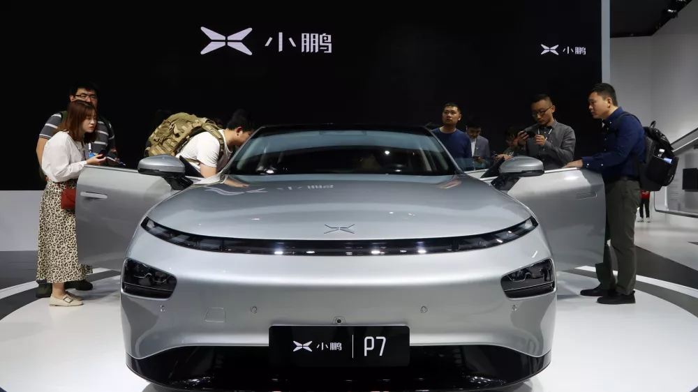FILE PHOTO: People look at XPeng's P7 sedan model displayed at the Guangzhou auto show in Guangzhou, Guangdong province, China November 22, 2019. Picture taken November 22, 2019. REUTERS/Yilei Sun/File Photo