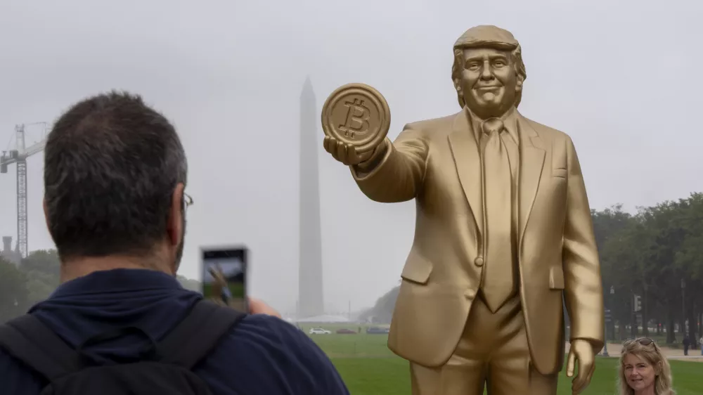 A statue of President Donald Trump holding a bitcoin in recognition of his support for cryptocurrency is displayed on the National Mall with the Washington Monument behind, Wednesday, Sept. 17, 2025, in Washington. (AP Photo/Alex Brandon)