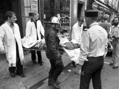 FILE - Rescuers carry an injured person on a stretcher from the scene of a terror attack at the Jo Goldenberg restaurant in Paris, France, Aug. 9, 1982. (AP Photo/Lionel Cironneau, File)