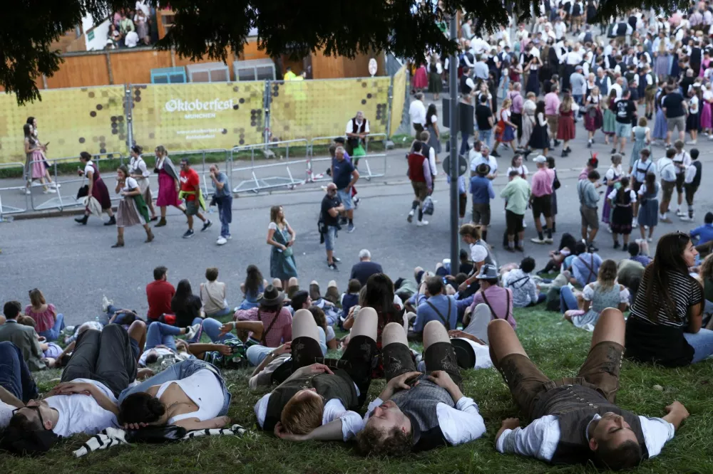 People lie on the ground on the day of the official opening of the 190th Oktoberfest, the world's largest beer festival in Munich, Germany, September 20, 2025. REUTERS/Maryam Majd
