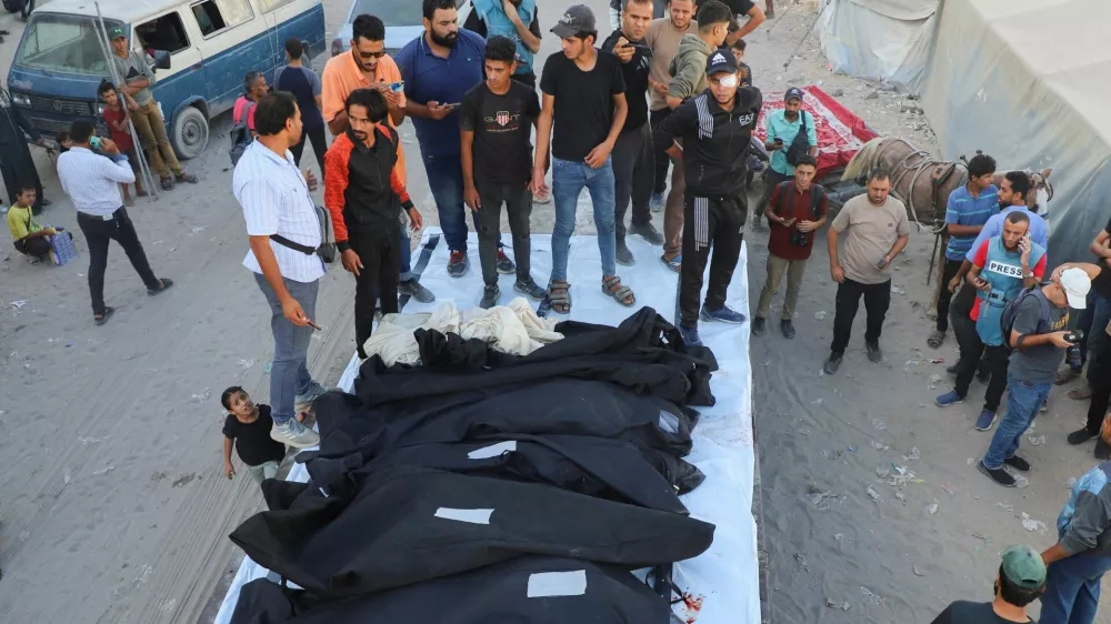 Mourners gather for a funeral around body bags containing the remains of the Dugmosh family, who were killed in an Israeli strike on a house on Saturday amid their military operation, according to medics, at Al-Shifa Hospital in Gaza City, September 21, 2025. REUTERS/Ebrahim Hajjaj