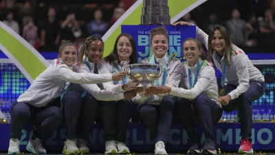 Italy's tennis team pose with the trophy on podium after winning the Billie Jean King Cup final against the United States, at the Shenzhen Bay Sports Center Arena, in Shenzhen, China's Guangdong province, Sunday, Sept. 21, 2025. (AP Photo/Andy Wong)