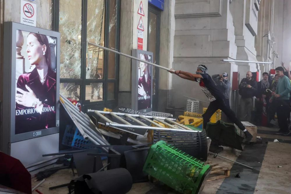 A protester uses a pole to break a window at Milano Centrale railway station, during a demonstration that is part of a nationwide "Let's Block Everything" protest in solidarity with Gaza, with activists also calling for a halt to arms shipments to Israel, in Milan, Italy September 22, 2025. REUTERS/Claudia Greco    TPX IMAGES OF THE DAY