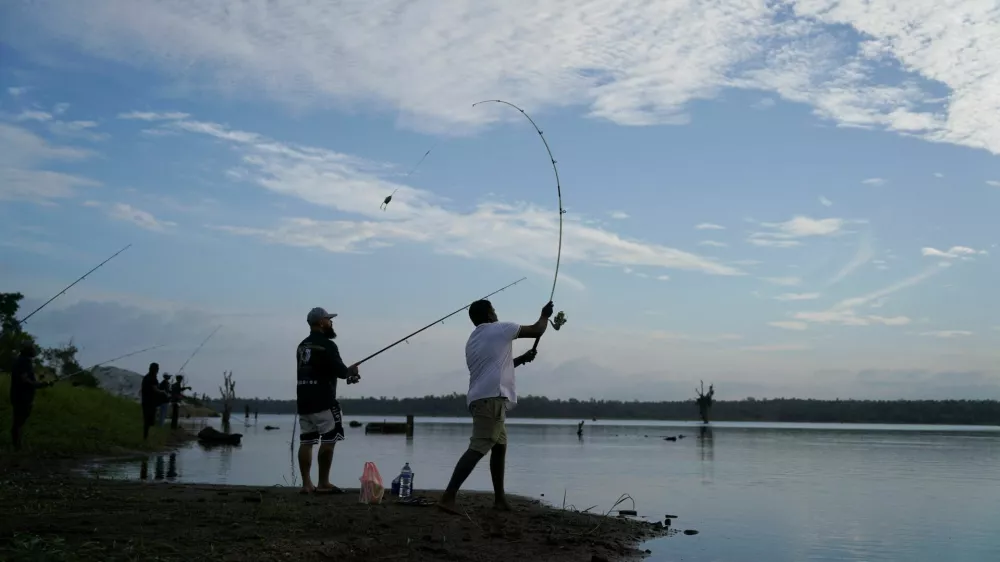 Participants try to catch giant snakehead fish at the Deduru Oya reservoir in Wariyapola, Sri Lanka, September 20, 2025. REUTERS/Thilina Kaluthotage