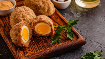Traditional Scotch Eggs on a wooden board, on a dark background. / Foto: Tbralnina