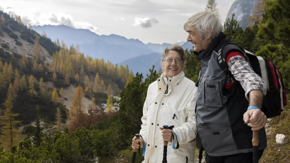 Serene Senior Couple Taking a Break on Hiking Trail in Beautiful Autumn Mountains / Foto: Robert Pavsic