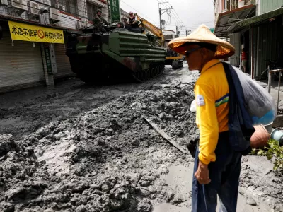 A man stands near a military vehicle on a road filled with mud brought by flooding, after Super Typhoon Ragasa in Hualien, Taiwan, September 24, 2025. REUTERS/Ann Wang   TPX IMAGES OF THE DAY