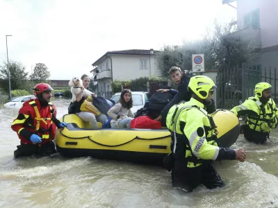 People are rescued by emergency services after heavy rainfall, in Tuscany, Italy, Saturday, Nov. 4, 2023. Record-breaking rain provoked floods in a vast swath of Tuscany as storm Ciar&aacute;n pushed into Italy overnight. At least six people were killed in that central Italian region. (Adriano Conte/LaPresse via AP)