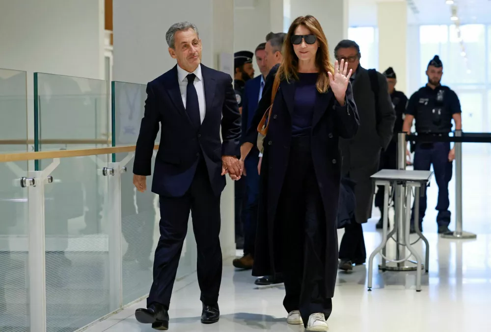 Former French President Nicolas Sarkozy arrives with his wife Carla Bruni-Sarkozy for the verdict in his trial with other defendants on charges of corruption and illegal financing of an election campaign related to alleged Libyan funding of his successful 2007 presidential bid, at the courthouse in Paris, France, September 25, 2025. REUTERS/Stephanie Lecocq