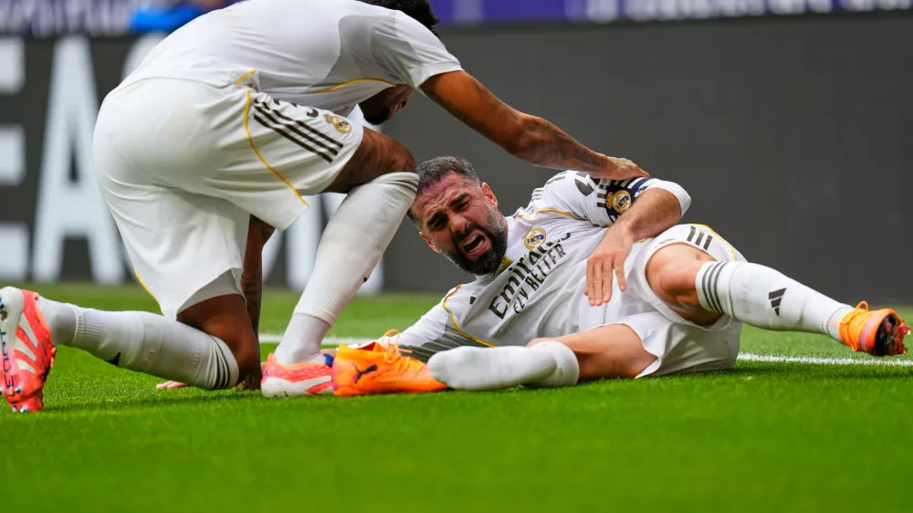 Real Madrid's Dani Carvajal, right, grimaces in pain after being tackled down during the Spanish La Liga soccer match between Atletico Madrid and Real Madrid at Metropolitano stadium, in Madrid, Spain, Saturday, Sept. 27, 2025. (AP Photo/Manu Fernandez)