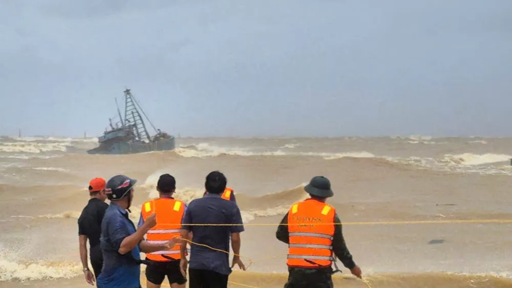 People work to rescue fishermen on a stranded fishing boat due to Typhoon Bualoi in Quang Tri, Vietnam Sunday, Sept. 28, 2025. (Trinh Quoc Dung/VNA via AP)