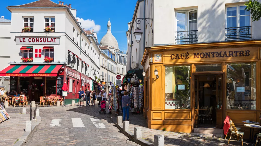 Paris, France - July 06, 2016: The charming quarter of Montmartre hill near basilica Sacre Coeur with traditional french cafes and art galleries. Montmartre is one of the most visited landmarks in Paris