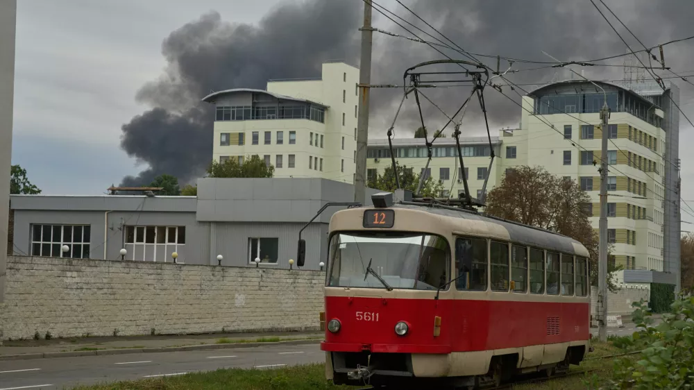 A public tram runs against the background of rising smoke during Russia's massive drone and missile attack in Kyiv, Ukraine, Sunday, Sept. 28, 2025. (AP Photo/Efrem Lukatsky)