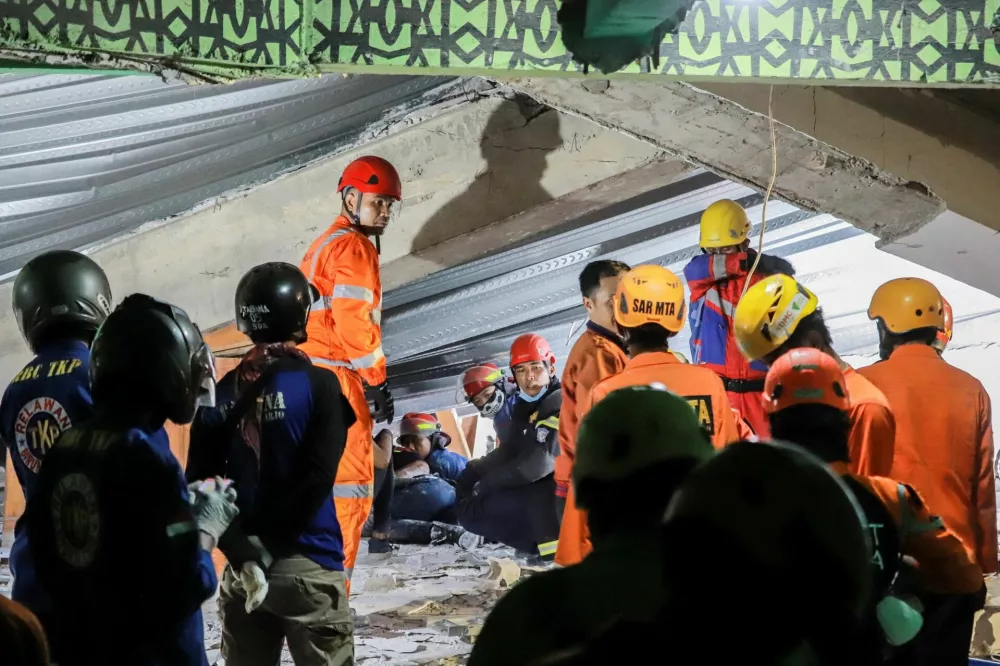Search and rescue officers search for victims amidst the rubble of a collapsed building after a hall collapsed while students were praying at the Al-Khoziny Islamic boarding school in Sidoarjo, East Java, Indonesia, September 29, 2025. REUTERS/Stringer