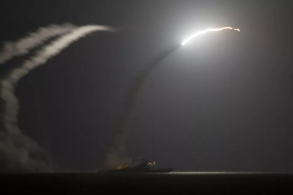 In this photo released by the U.S. Navy, the guided-missile cruiser USS Philippine Sea launches a Tomahawk cruise missile at Islamic State group positions in Syria as seen from the aircraft carrier USS George H.W. Bush in the Arabian Gulf on Tuesday, Sept. 23, 2014. Syria said Tuesday that Washington informed President Bashar Assad's government of imminent U.S. airstrikes against the Islamic State group, hours before an American-led military coalition pounded the extremists' strongholds across northern and eastern Syria.(AP Photo/Eric Garst, U.S. Navy)