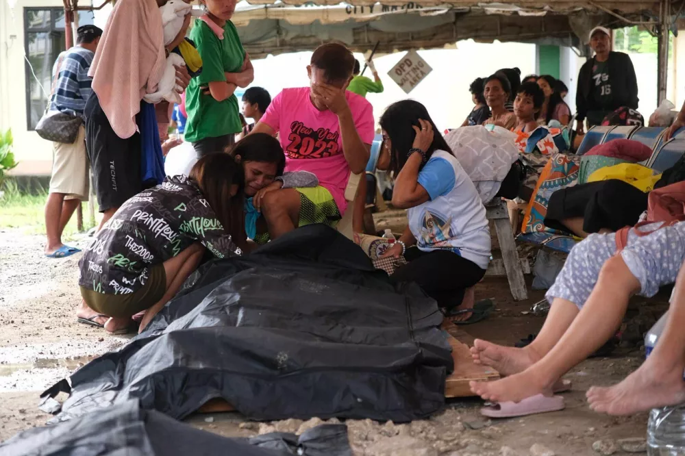 People surround a body bag in Bogo City, Cebu province, Philippines Wednesday, Oct. 1, 2025 after an offshore earthquake on late Tuesday. (AP Photo)