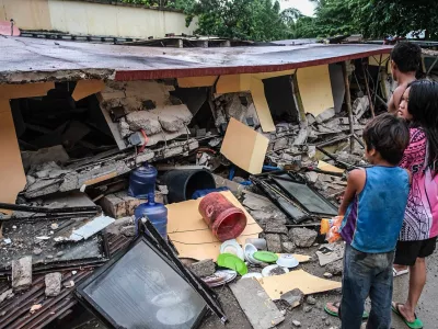 People look at a collapsed building in Bogo City, Cebu province, Philippines Wednesday, Oct. 1, 2025 after an offshore earthquake on late Tuesday. (AP Photo)