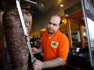 Ahmet Guenaes, Mitarbeiter des Doener-Imbiss Halici, schneidet am Mittwoch, 23. April 2008, in Berlin Doenerfleisch von einem Spiess. In der Hauptstadt koennen Doener-Liebhaber auch Doener bestellen, die mit Neuland-Fleisch aus tiergerechter Haltung hergestellt werden. (AP Photo/Miguel Villagran)---Ahmet Guenaes cuts meat for a kebab sandwich during a promotional event for high quality kebab meat in Berlin, on Wednesday, April 23, 2008. (AP Photo/Miguel Villagran)