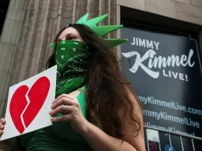 A woman wears a Statue of Liberty costume as she holds an image of a broken heart, outside the El Capitan Entertainment Centre, where "Jimmy Kimmel Live!" is recorded for broadcast, on Hollywood Boulevard in Los Angeles, California, U.S. September 17, 2025. REUTERS/Daniel Cole   TPX IMAGES OF THE DAY / Foto: Daniel Cole
