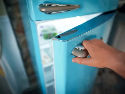 Man opening door of retro refrigerator freezer. / Foto: M-production
