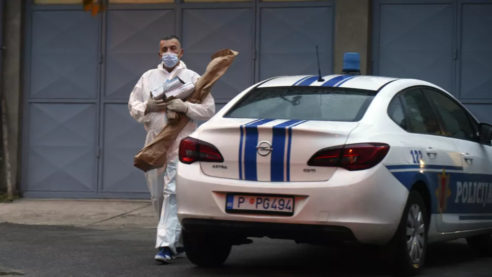 REMOVES SPECIFIC NUMBER OF CASUALTIES AND CLARIFIES SHOOTING DETAILS A police investigator holds evidence material on the site of the attack in Cetinje, some 30 km west of Podgorica, Montenegro, Friday, Aug. 12, 2022. A man went on a shooting rampage in the streets of a western Montenegro city Friday, killing multiple people, before being shot dead by a passerby, officials said. (AP Photo/Risto Bozovic)
