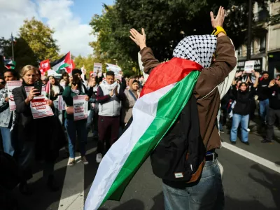 A protester wears a Palestinian flag over their shoulders during a demonstration in support of Palestinians, calling for an end to the war in Gaza, to condemn the Israeli forces' interception of the vessels of the Global Sumud Flotilla which were aiming to reach Gaza and break Israel's naval blockade, and for the release of the crews, in Paris, France, October 4, 2025. REUTERS/Stephane Mahe