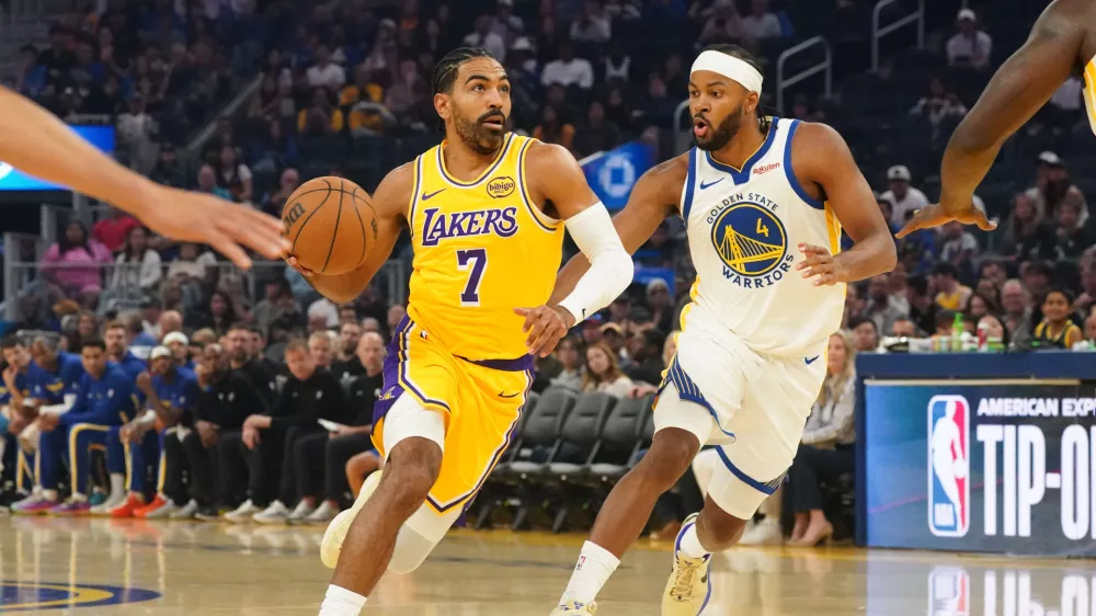 Oct 5, 2025; San Francisco, California, USA; Los Angeles Lakers guard Gabe Vincent (7) dribbles to the basket against Golden State Warriors guard Moses Moody (4) in the first quarter at Chase Center. Mandatory Credit: David Gonzales-Imagn Images