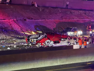 Law enforcement officers stand near the wreckage of a helicopter that crashed on eastbound Highway 50 in Sacramento, Calif., Monday, Oct. 6, 2025. (Robert Petersen via AP)