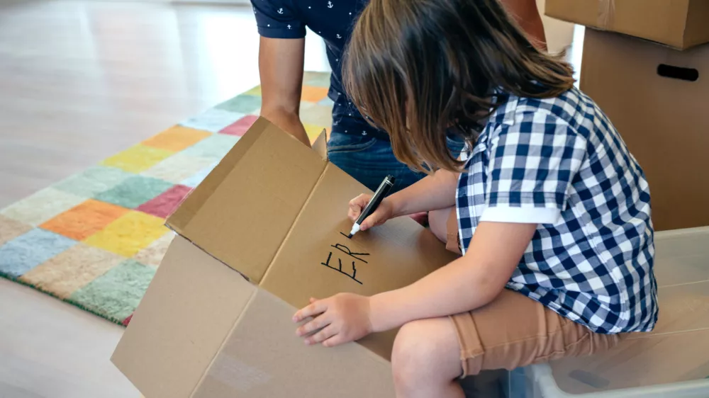 Deček, ki na &scaron;katlo zapisuje svoje ime. / Foto: Istock