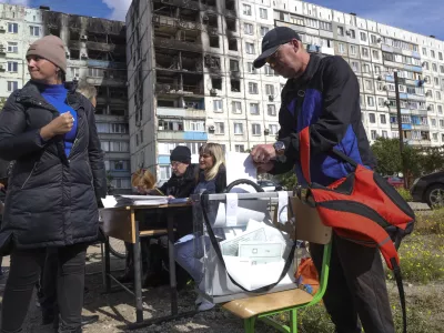 People vote at a mobile polling station during a referendum in Mariupol, Donetsk People's Republic, controlled by Russia-backed separatists, in eastern Ukraine, Saturday, Sept. 24, 2022. Voting began Friday in four Moscow-held regions of Ukraine on referendums to become part of Russia. Polls also opened in Russia, where refugees from regions under Russian control can cast their votes. (AP Photo)
