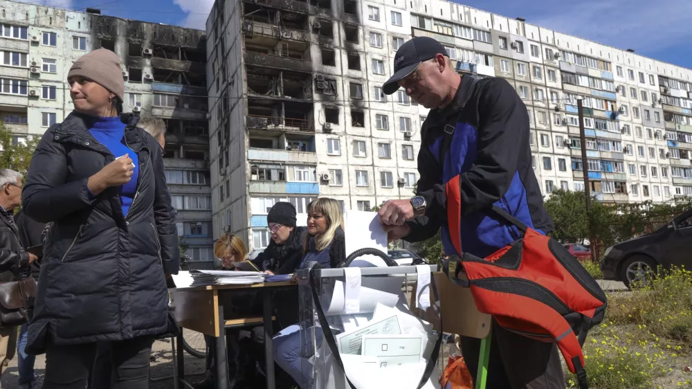 People vote at a mobile polling station during a referendum in Mariupol, Donetsk People's Republic, controlled by Russia-backed separatists, in eastern Ukraine, Saturday, Sept. 24, 2022. Voting began Friday in four Moscow-held regions of Ukraine on referendums to become part of Russia. Polls also opened in Russia, where refugees from regions under Russian control can cast their votes. (AP Photo)