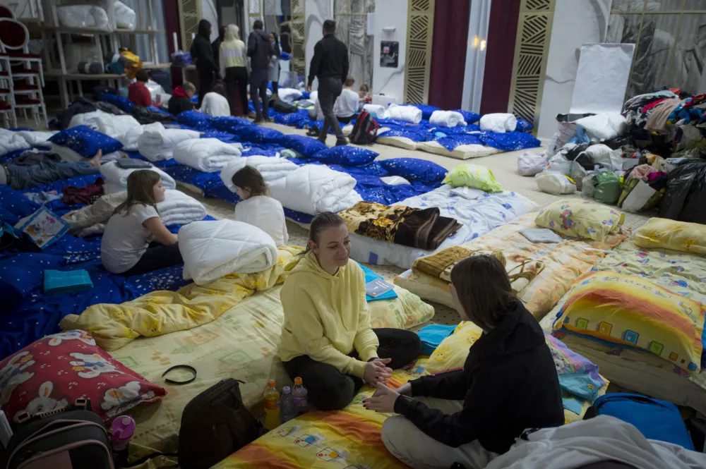 Refugees fleeing the conflict from neighbouring Ukraine talk in the event hall of a hotel offering shelter in Siret, Romania, Saturday, Feb. 26, 2022. Romania, which shares around 600 kilometres (372 miles) of borders with Ukraine to the north, is seeing an influx of refugees from the country as many flee Russia's attacks. (AP Photo/Alexandru Dobre)