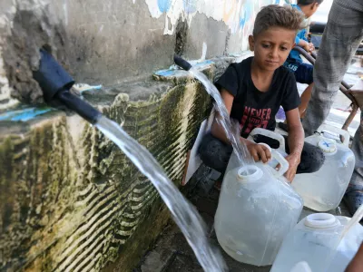 A displaced Palestinian boy fills a container with water, in Deir Al-Balah, central Gaza Strip, October 8, 2025. REUTERS/Dawoud Abu Alkas